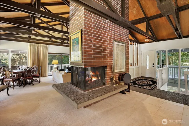 a living room with furniture a fireplace and large windows