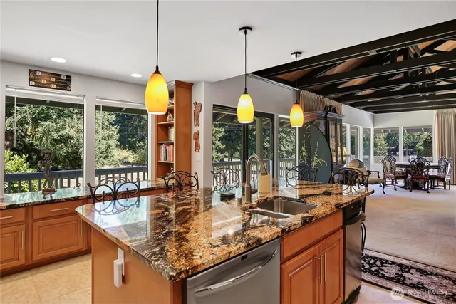 a kitchen with counter top space and large windows