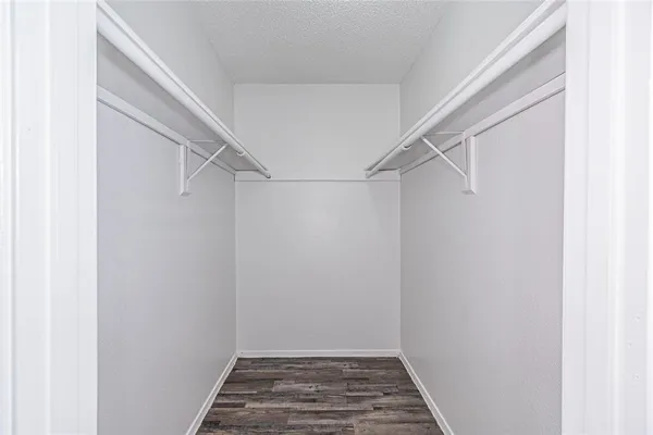 a view of empty room with wooden floor fireplace and fan