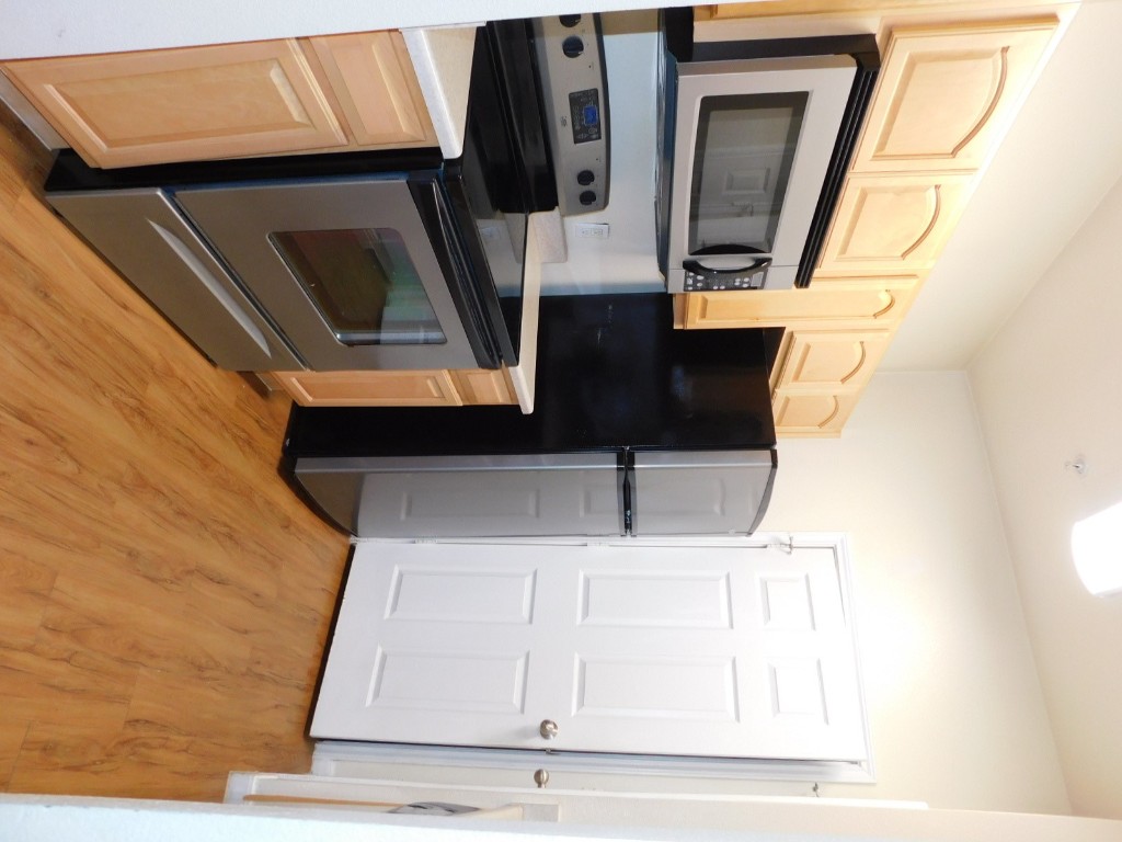 12166 Metric Boulevard, Unit 153 Austin, TX 78758 - Photo 1 of 8 a kitchen with a refrigerator stove and microwave