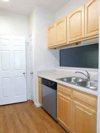 a kitchen with stainless steel appliances granite countertop a sink and dishwasher with wooden floor