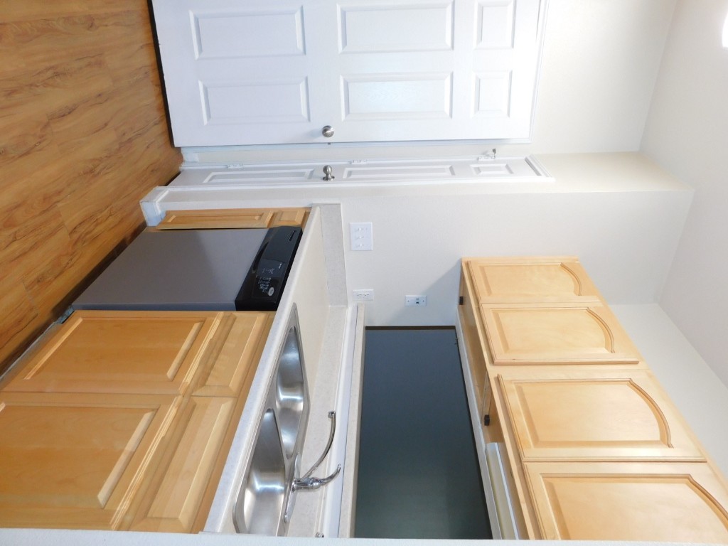 12166 Metric Boulevard, Unit 153 Austin, TX 78758 - Photo 2 of 8 a kitchen with stainless steel appliances granite countertop a sink and dishwasher with wooden floor