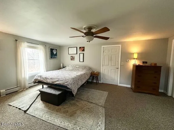 a spacious bedroom with a bed and a flat screen tv