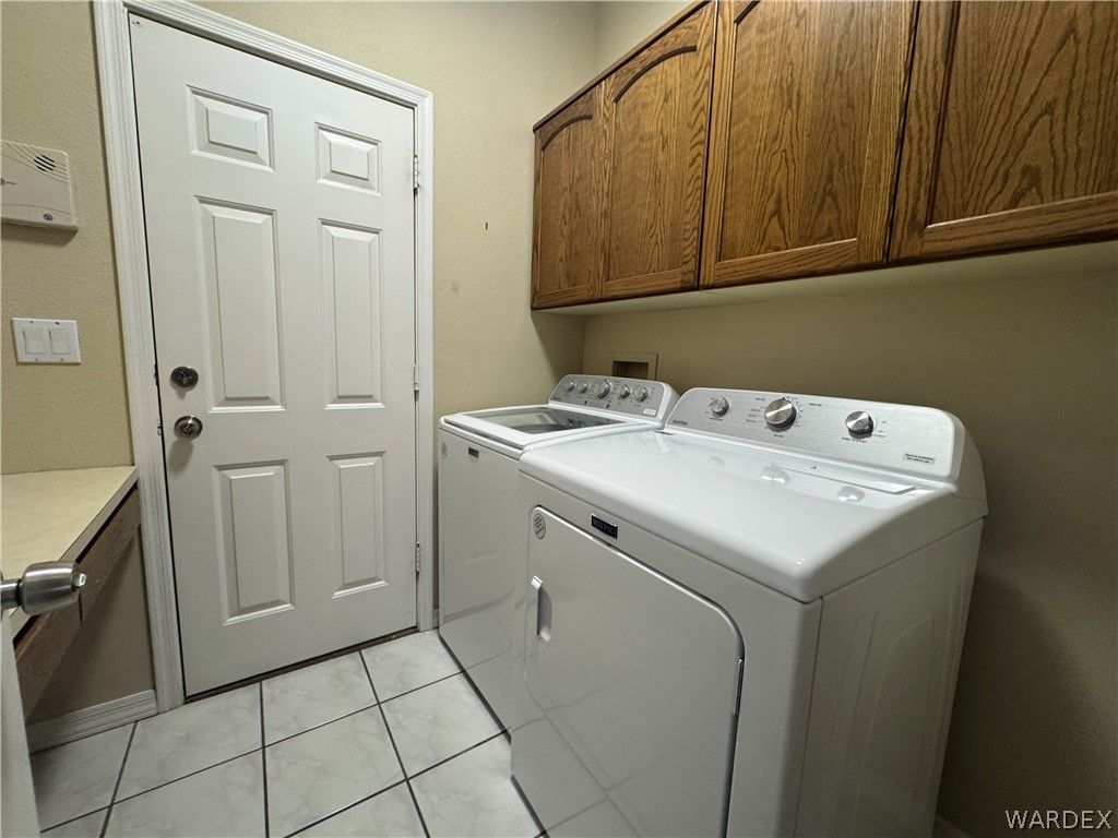 3323 North Ridge Avenue Bullhead City, AZ 86429 - Photo 18 of 24 Laundry area featuring tile flooring, wooden cabinetry, and a countertop