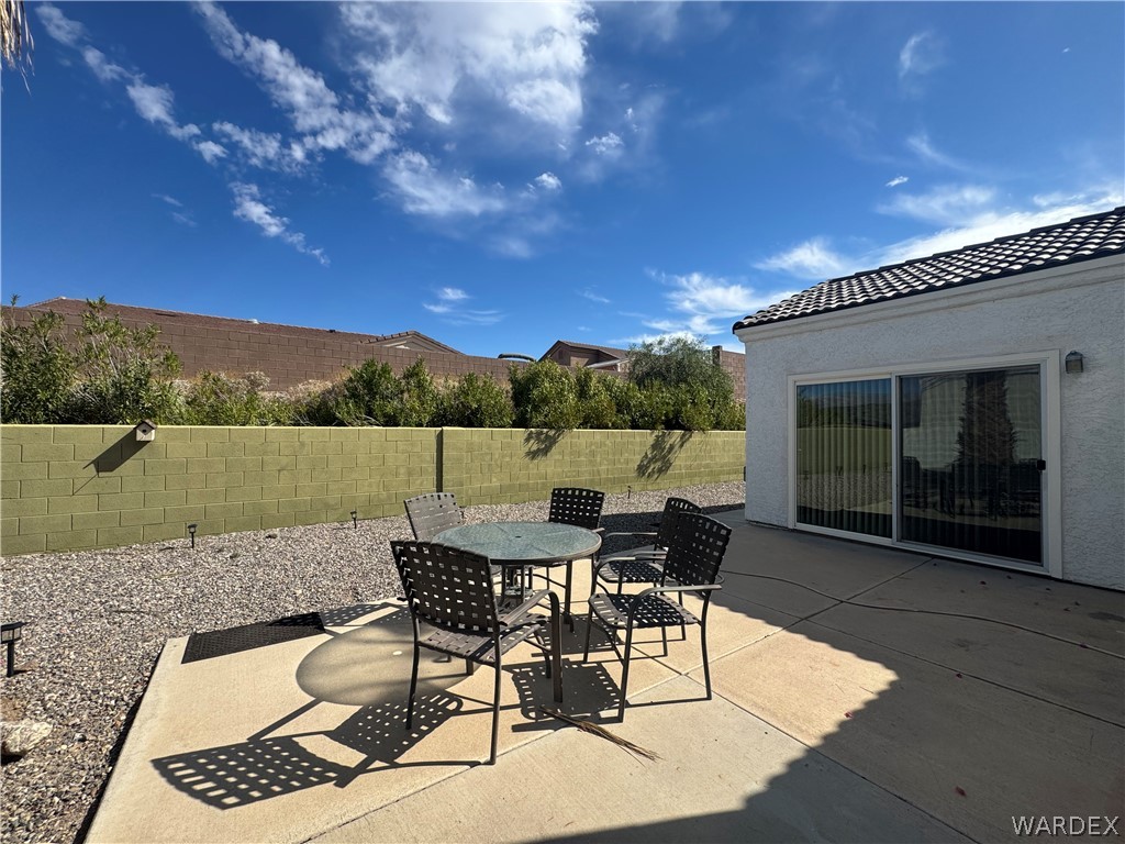 3323 North Ridge Avenue Bullhead City, AZ 86429 - Photo 19 of 24 The property features a concrete patio area, a sliding glass door, and a textured stucco exterior