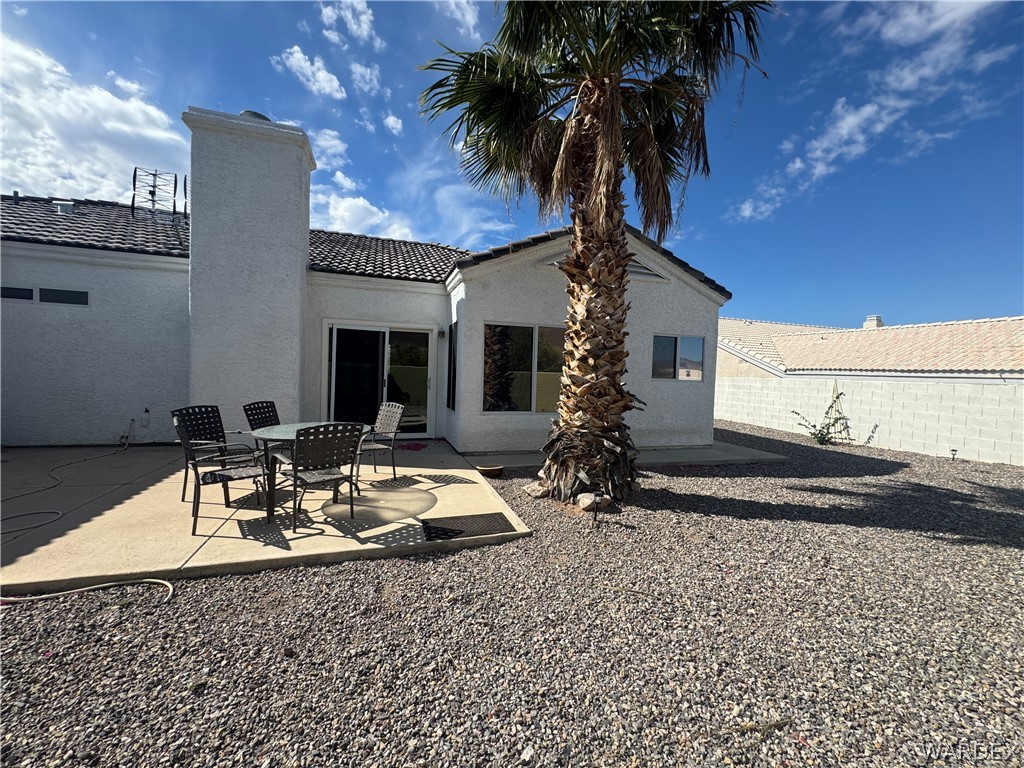 3323 North Ridge Avenue Bullhead City, AZ 86429 - Photo 21 of 24 The property features a concrete patio area, a stucco exterior, and a visible chimney