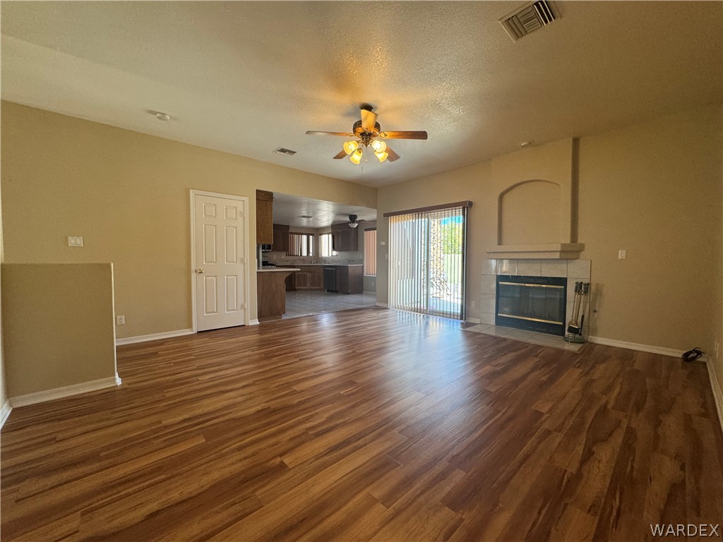 3323 North Ridge Avenue Bullhead City, AZ 86429 - Photo 7 of 24 The main living area features wood-look flooring, a ceiling fan, and a fireplace with a decorative arched niche