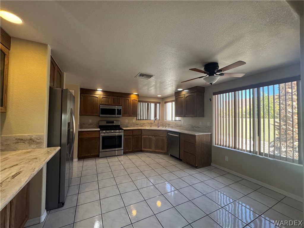3323 North Ridge Avenue Bullhead City, AZ 86429 - Photo 8 of 24 The kitchen features extensive counter space with light-colored countertops, wood cabinetry, and stainless steel appliances