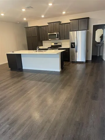 a kitchen with stainless steel appliances a refrigerator sink and microwave