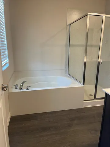 a view of bathroom with bathtub and wooden floor