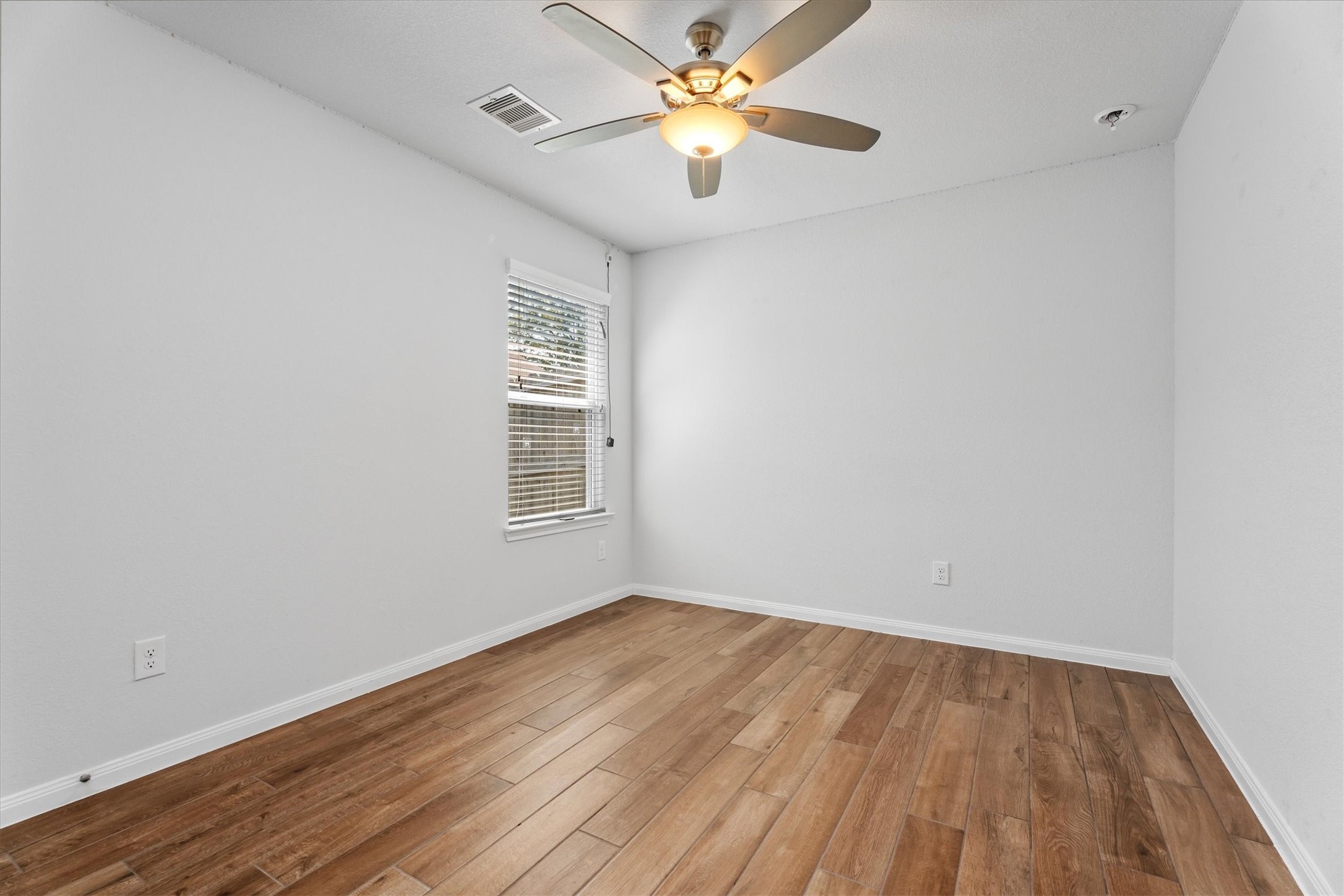 12912 Lake Conroe Bay Road Willis, TX 77318 - Photo 21 of 33 a view of a room with wooden floor and a ceiling fan
