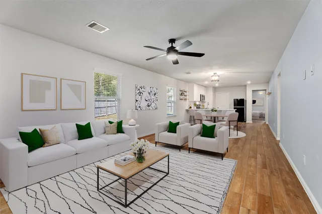 a living room with furniture and view of kitchen