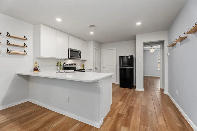 a kitchen with stainless steel appliances granite countertop a refrigerator stove top oven and sink