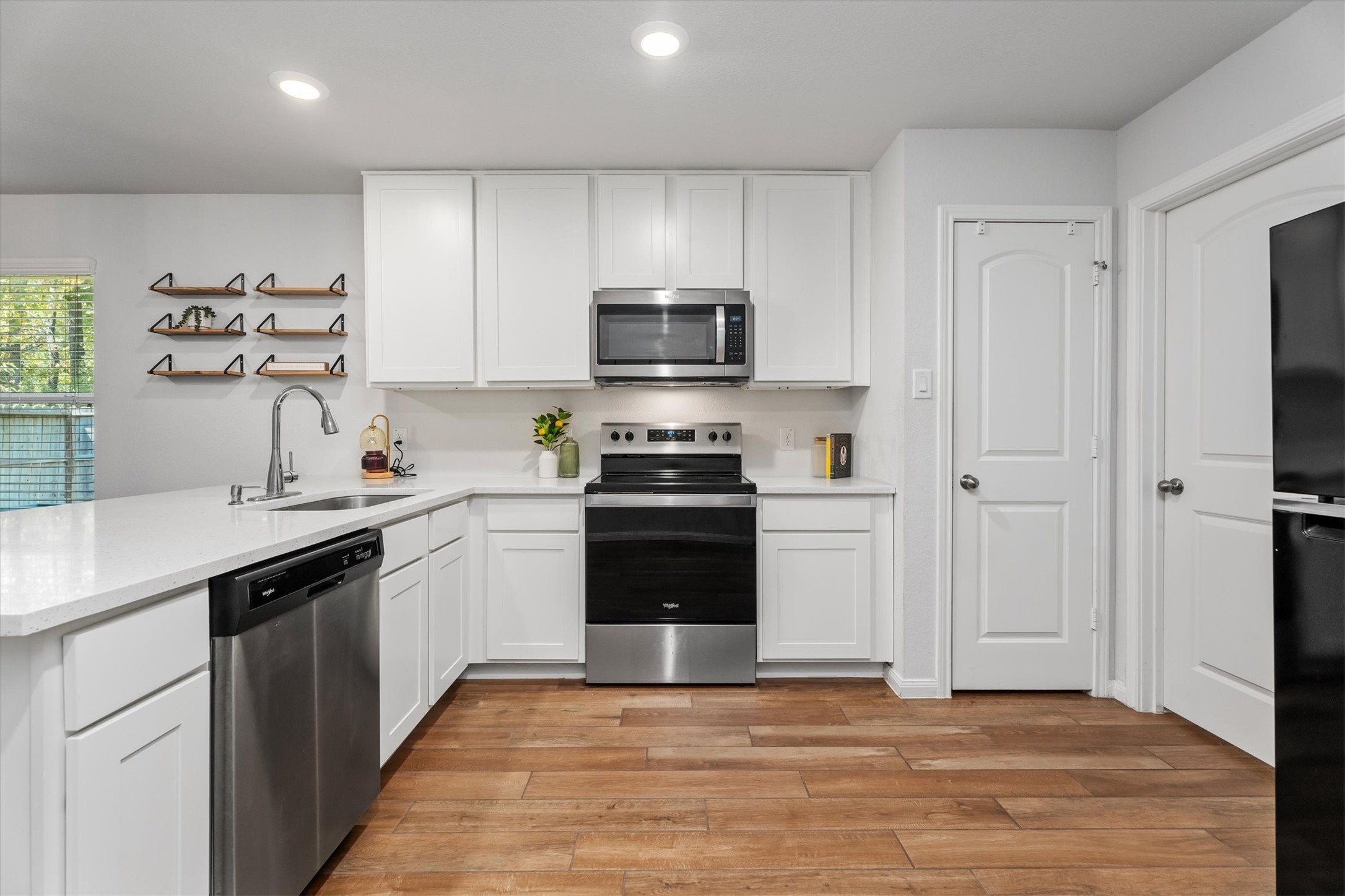 12912 Lake Conroe Bay Road Willis, TX 77318 - Photo 8 of 33 a kitchen with a refrigerator and a stove top oven