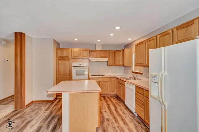 a kitchen with refrigerator a stove a sink and cabinets