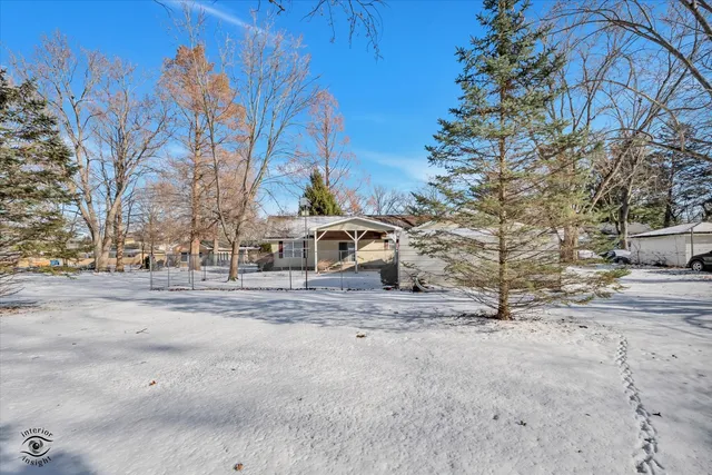 a front view of a house with a yard covered with snow