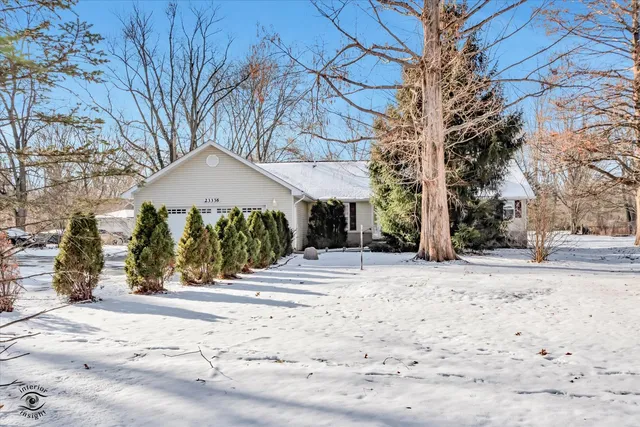 a front view of a house with a yard covered with snow