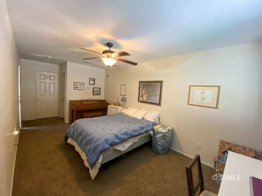 1109 Rebecca Avenue Ridgecrest, CA 93555 - Photo 29 of 50 a bedroom with a bed and a chandelier