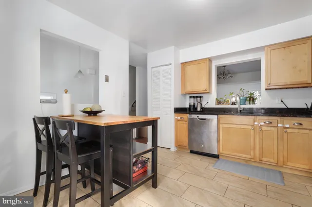 a kitchen with a table chairs sink and cabinets