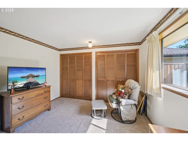 a living room with furniture a flat screen tv and a window