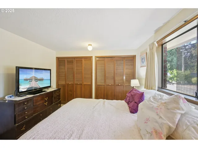 a bedroom with a bed and a flat screen tv