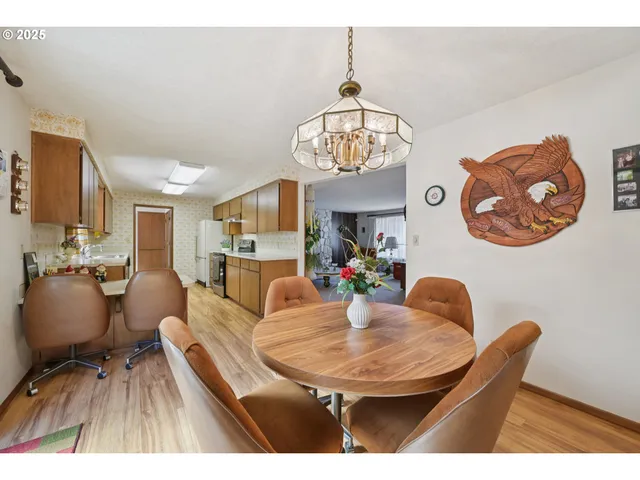 a dining room with furniture a chandelier and wooden floor