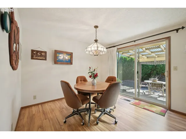 a dining room with furniture a chandelier and wooden floor