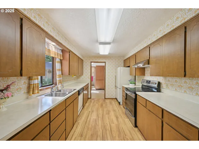 a large kitchen with a lot of counter space and wooden floor