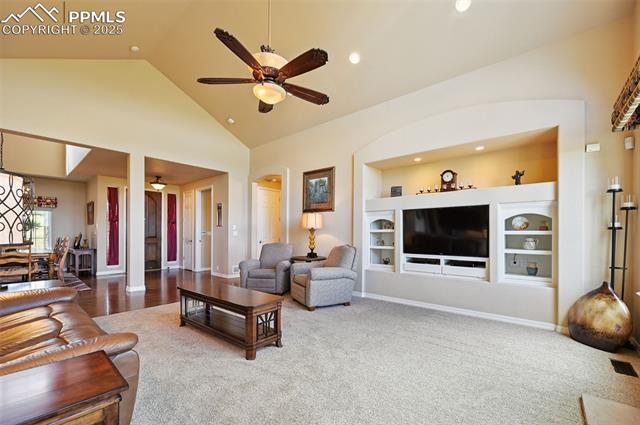 1918 Bashley Road Monument, CO 80132 - Photo 11 of 48 Carpeted living area with ceiling fan, built in shelves, high vaulted ceiling, recessed lighting, and arched walkways