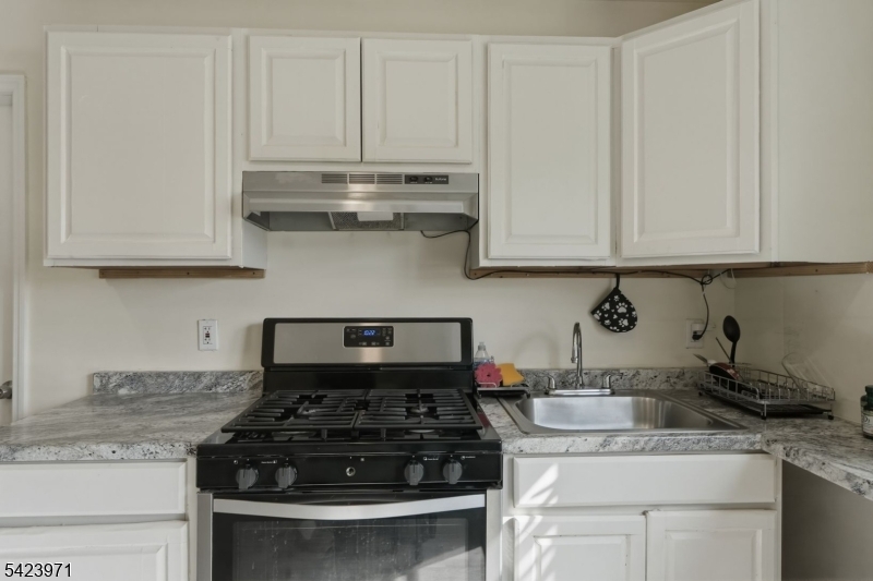172 Carroll Street Paterson, NJ 07501 - Photo 8 of 48 a kitchen with granite countertop white cabinets and a stove