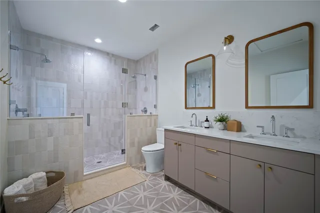 a bathroom with 2 sink toilet and shower