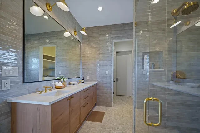 a bathroom with a double vanity sink a mirror and a shower