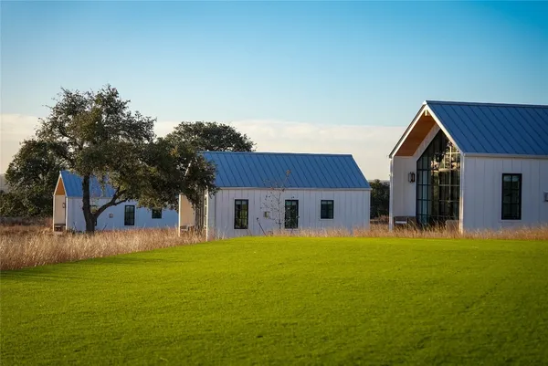 a front view of house with yard and trees in the background