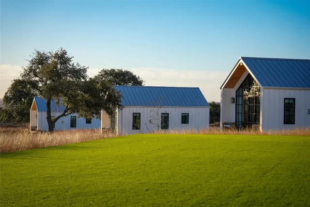 a front view of house with yard and trees in the background
