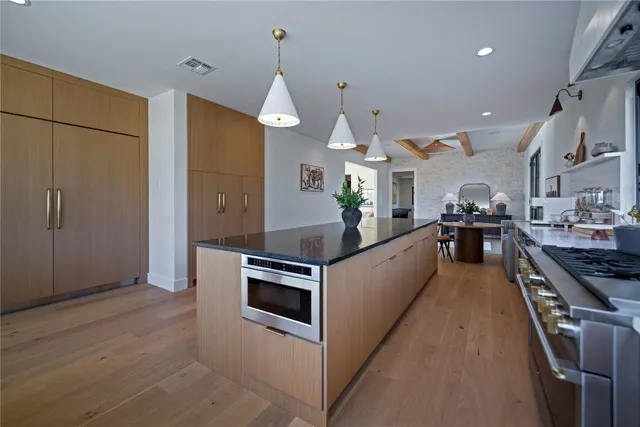 a large kitchen with stainless steel appliances kitchen island granite countertop a large counter top and stove