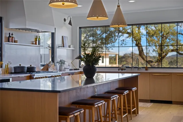 a kitchen with stainless steel appliances a sink and a large window