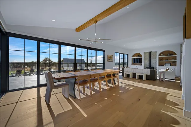 a living room with furniture a floor to ceiling window and flat screen tv