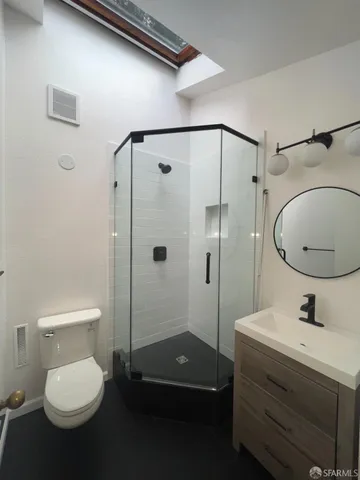 a bathroom with a sink a toilet and shower
