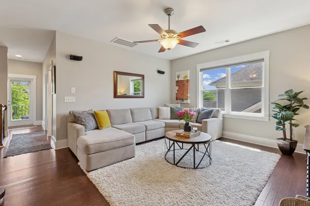 a living room with furniture a potted plant and a large window