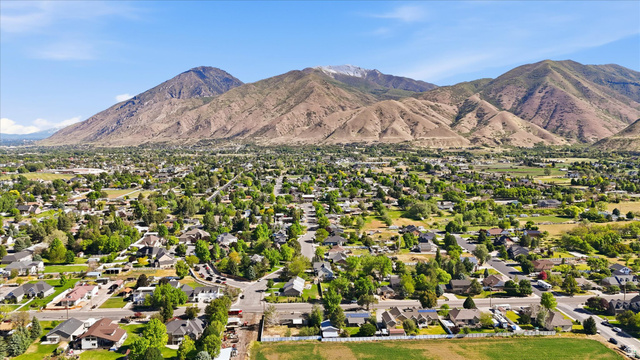 810 East Maple Street Mapleton, UT 84664 - Photo 44 of 49 Expansive aerial perspective showcasing a residential area with mature tree coverage and mountainous terrain in the background