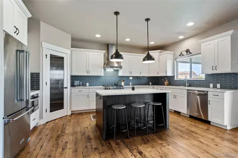 a large kitchen with stainless steel appliances granite countertop a stove a sink and a refrigerator