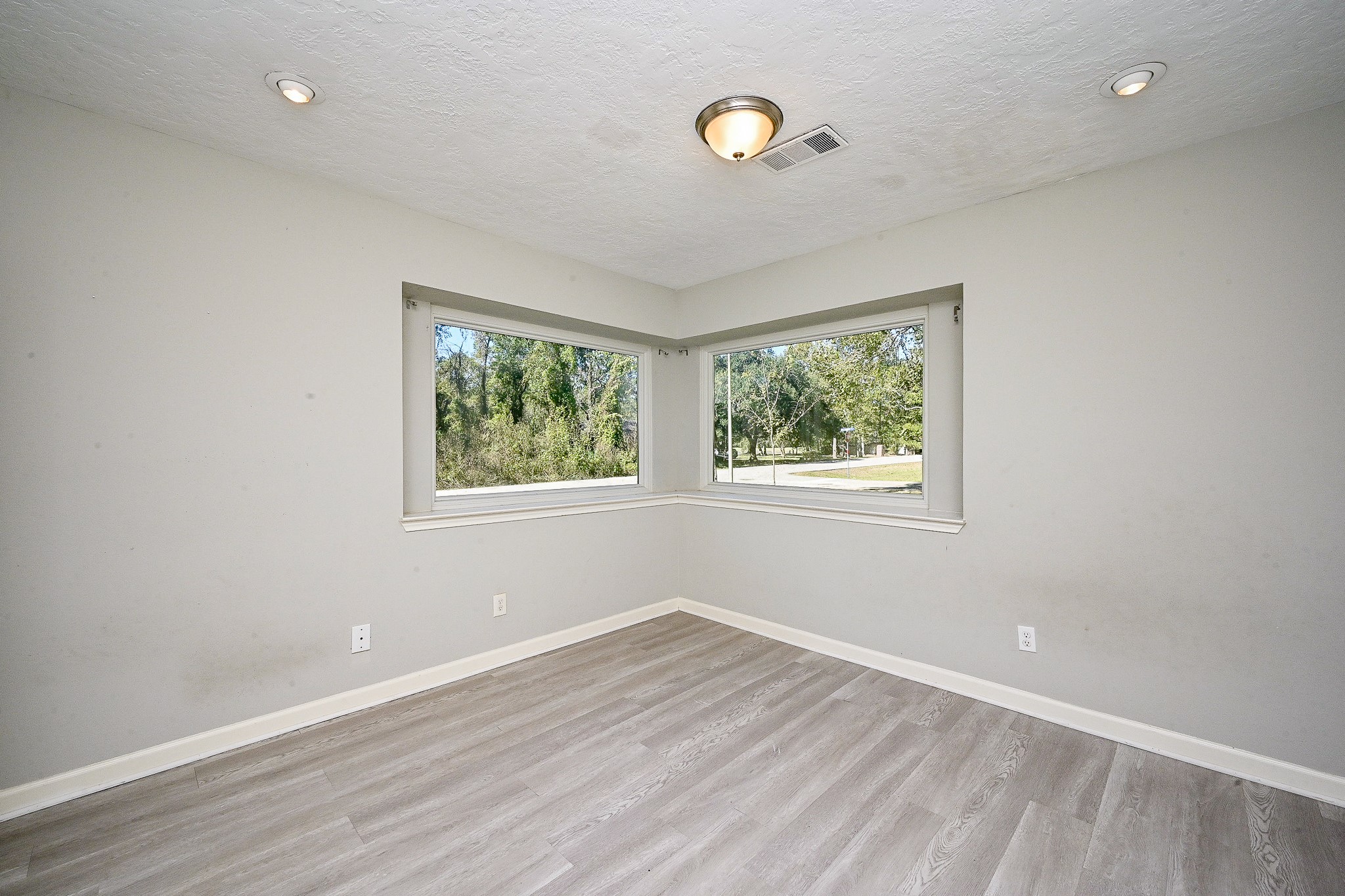 602 Mobile Court Conroe, TX 77302 - Photo 14 of 30 an empty room with wooden floor and windows