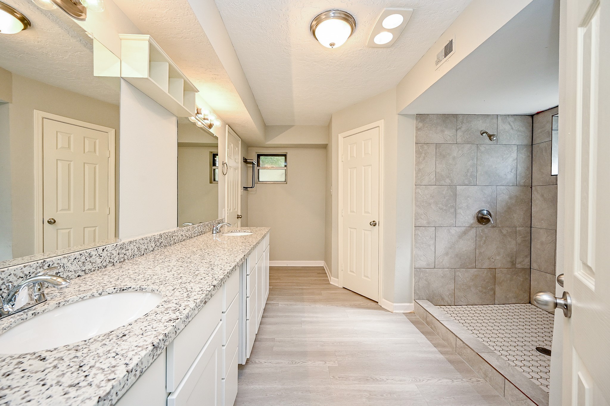 602 Mobile Court Conroe, TX 77302 - Photo 20 of 30 a spacious bathroom with a granite countertop sink a mirror and shower
