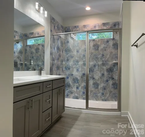 a bathroom with a shower sink vanity and mirror