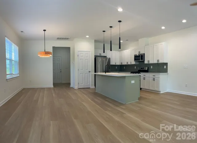 a kitchen with stainless steel appliances kitchen island wooden cabinets and granite counter tops