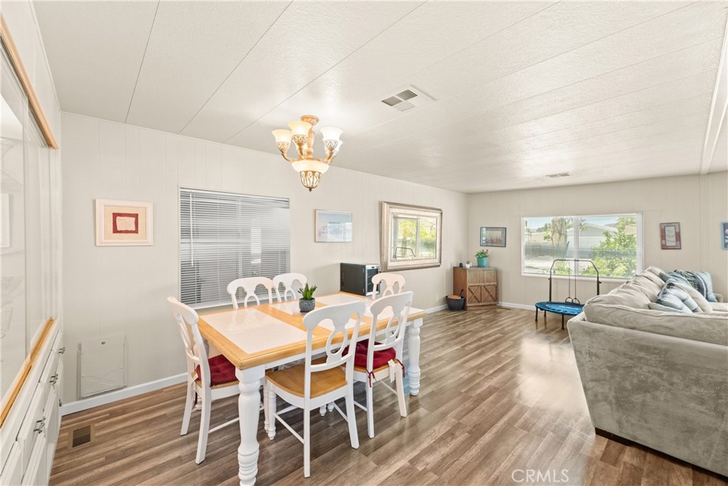 2964 Silver Oak Way Hemet, CA 92545 - Photo 17 of 60 a view of a dining room with furniture a chandelier and wooden floor