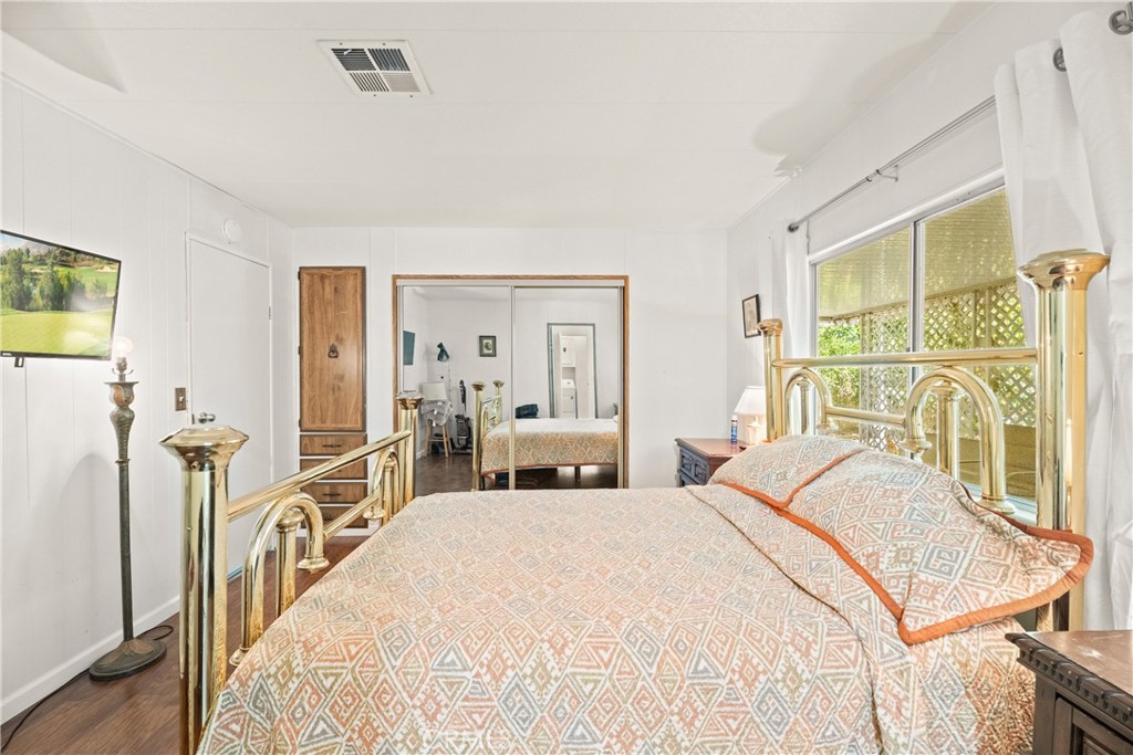 2964 Silver Oak Way Hemet, CA 92545 - Photo 39 of 60 a bedroom with a bed and a large mirror next to a window