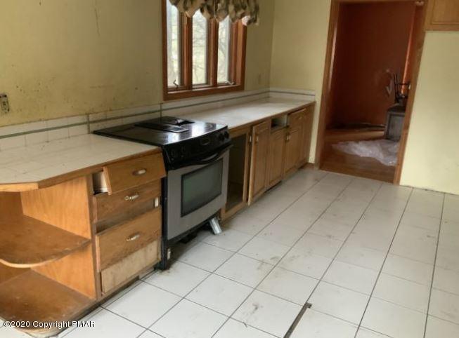 400 Blue Ridge Road Saylorsburg, PA 18353 - Photo 5 of 13 a kitchen with granite countertop a stove a sink and a microwave