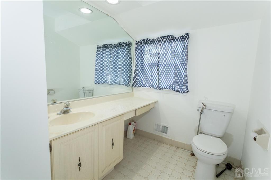 3301 Stonehedge Road, Unit 3301 Edison, NJ 08820 - Photo 19 of 25 a bathroom with a sink toilet and mirror