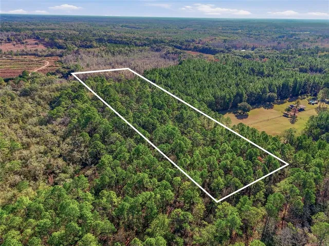 an aerial view of a houses with a yard